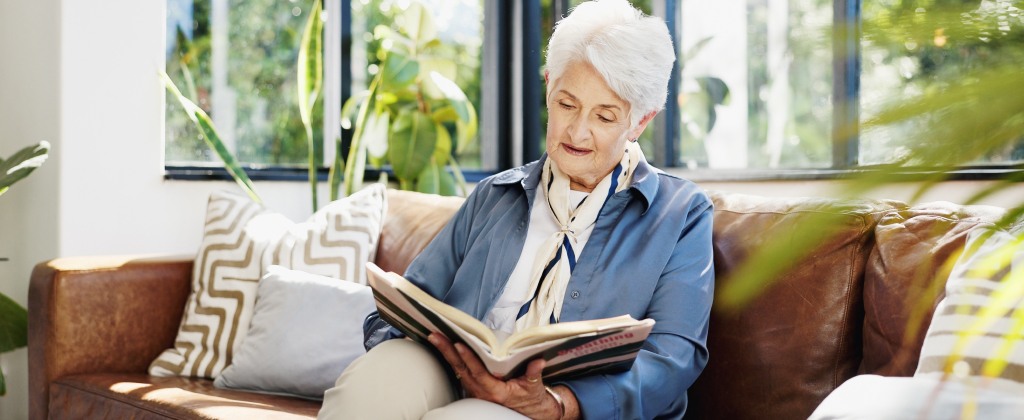 Woman relaxing and reading in a warm, comfortable living space