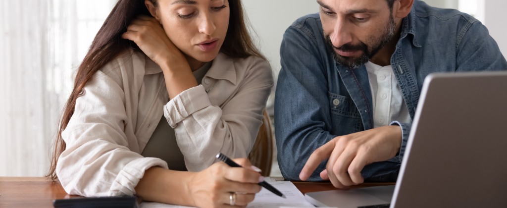 Homeowners comparing conservatory roof quotes and costs on a laptop